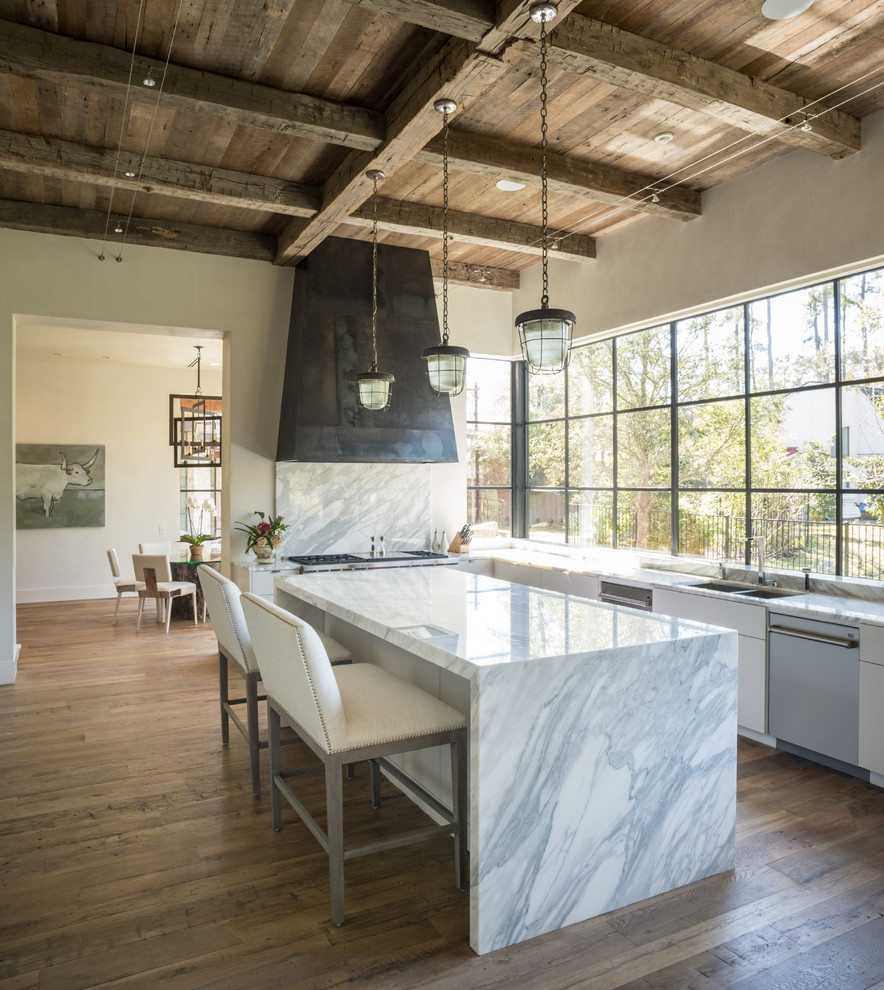 This is an example of a contemporary l-shaped kitchen in Houston with a double-bowl sink, flat-panel cabinets, white cabinets, stainless steel appliances, medium hardwood floors, with island and marble splashback.