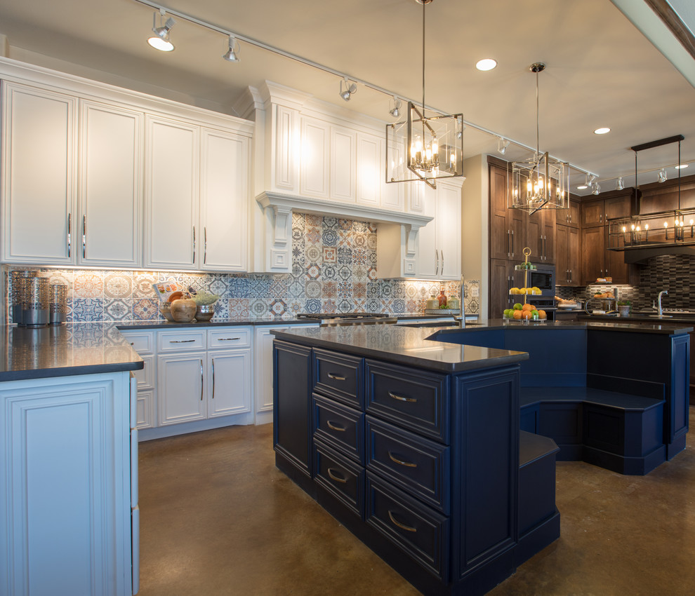Inspiration for a mid-sized transitional single-wall concrete floor and brown floor eat-in kitchen remodel in Austin with an undermount sink, recessed-panel cabinets, white cabinets, granite countertops, multicolored backsplash, ceramic backsplash, stainless steel appliances, an island and black countertops
