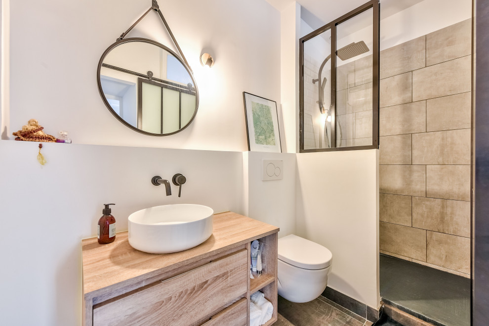 Inspiration for a mid-sized contemporary 3/4 bathroom in Paris with flat-panel cabinets, beige cabinets, an alcove shower, a wall-mount toilet, gray tile, porcelain tile, white walls, a vessel sink, wood benchtops, grey floor, an open shower and beige benchtops.