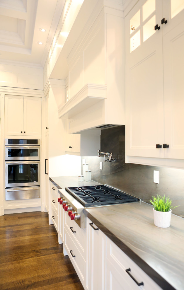 Inspiration for a mid-sized transitional l-shaped open concept kitchen remodel in Toronto with flat-panel cabinets, white cabinets, wood countertops, brown backsplash and an island