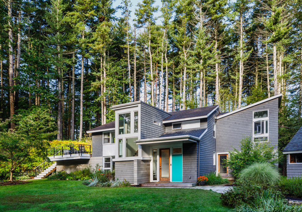 Идея дизайна: двухэтажный, деревянный, серый частный загородный дом среднего размера в стиле ретро с односкатной крышей, крышей из гибкой черепицы, черной крышей и отделкой дранкой