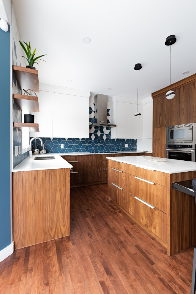 Mid-sized trendy u-shaped dark wood floor and brown floor eat-in kitchen photo in Calgary with a double-bowl sink, flat-panel cabinets, medium tone wood cabinets, quartz countertops, multicolored backsplash, porcelain backsplash, stainless steel appliances, an island and white countertops