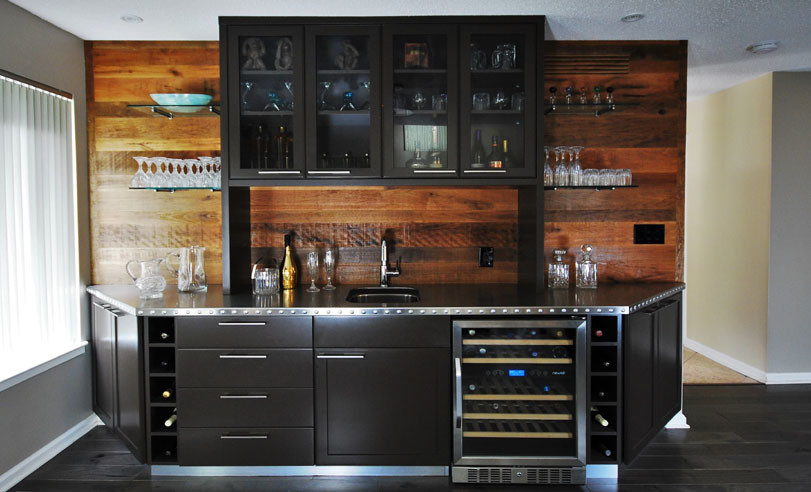 Transitional wet bar in Philadelphia with an undermount sink, shaker cabinets, black cabinets, stainless steel benchtops and dark hardwood floors.