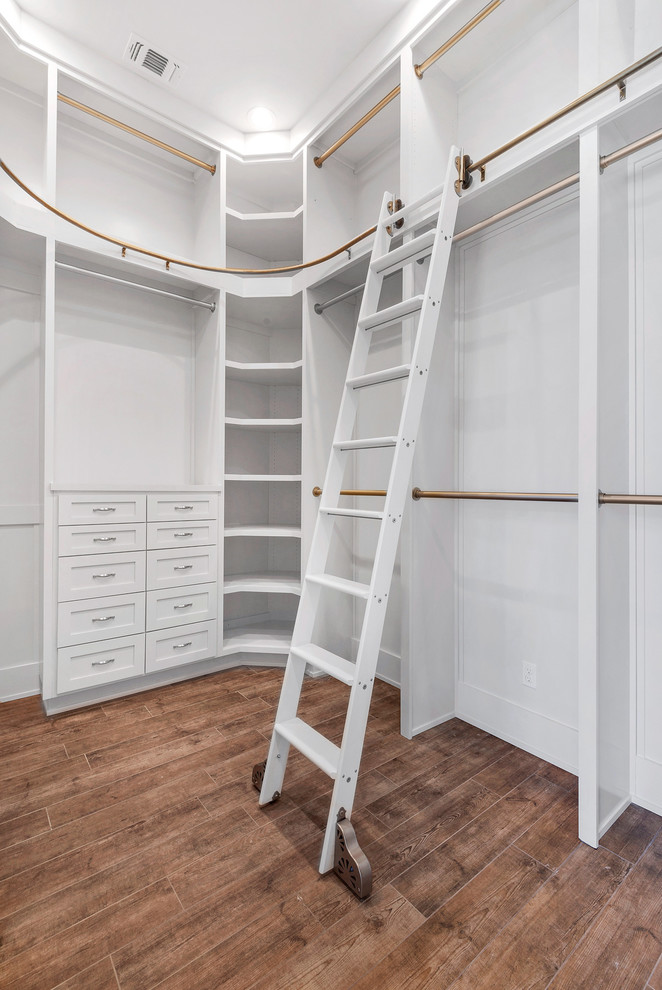 Design ideas for a large transitional gender-neutral walk-in wardrobe in Miami with shaker cabinets, white cabinets, medium hardwood floors and brown floor.