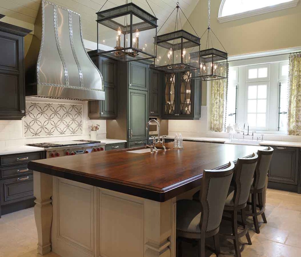 Large traditional galley kitchen in Raleigh with an undermount sink, dark wood cabinets, wood benchtops, stainless steel appliances, with island, raised-panel cabinets, black splashback, stone slab splashback and ceramic floors.