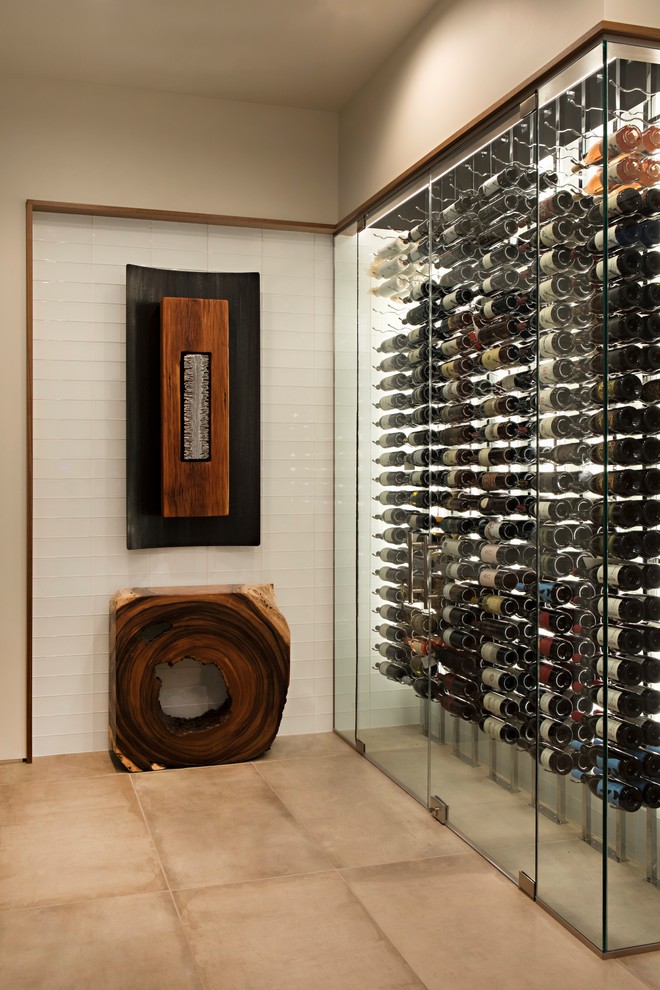 This is an example of a large contemporary wine cellar in Phoenix with limestone floors, display racks and beige floor.