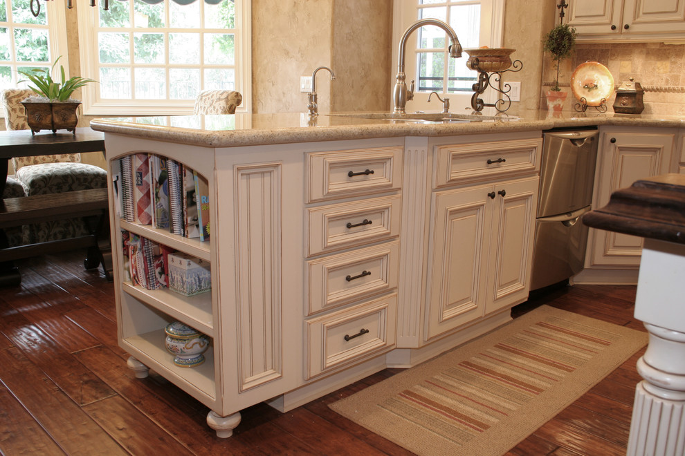 Design ideas for a large traditional u-shaped kitchen pantry in Orange County with an undermount sink, raised-panel cabinets, white cabinets, granite benchtops, beige splashback, stone tile splashback, stainless steel appliances, medium hardwood floors and with island.