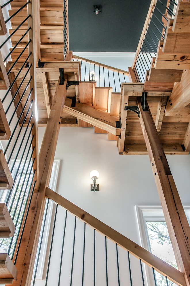 This is an example of a large modern wood u-shaped staircase in Other with open risers and wood railing.