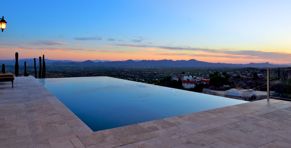 Inspiration for a mid-sized transitional backyard stone and rectangular infinity pool remodel in Phoenix