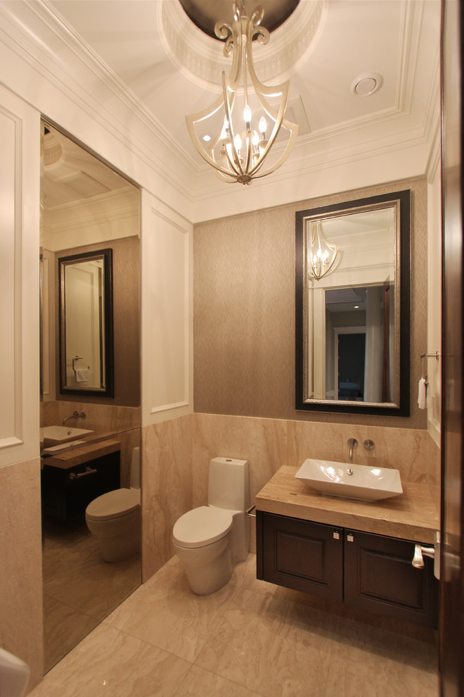 Large eclectic powder room in Vancouver with a vessel sink, raised-panel cabinets, dark wood cabinets, marble benchtops, a one-piece toilet, beige tile, stone slab, beige walls, marble floors and beige benchtops.