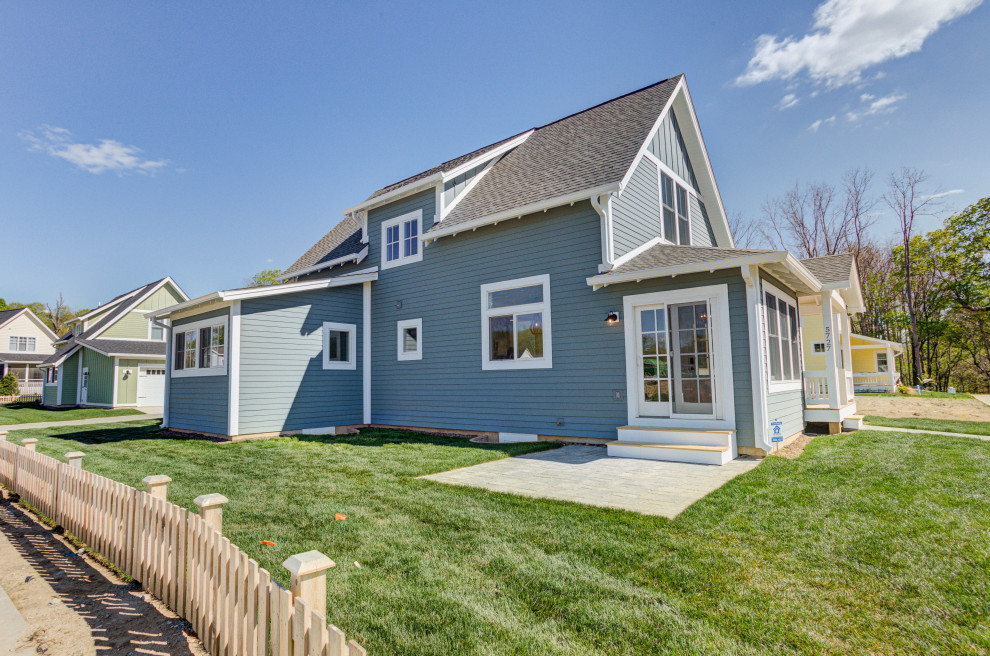 Стильный дизайн: двухэтажный, синий частный загородный дом среднего размера в стиле кантри с облицовкой из ЦСП, крышей из гибкой черепицы, черной крышей и отделкой доской с нащельником - последний тренд