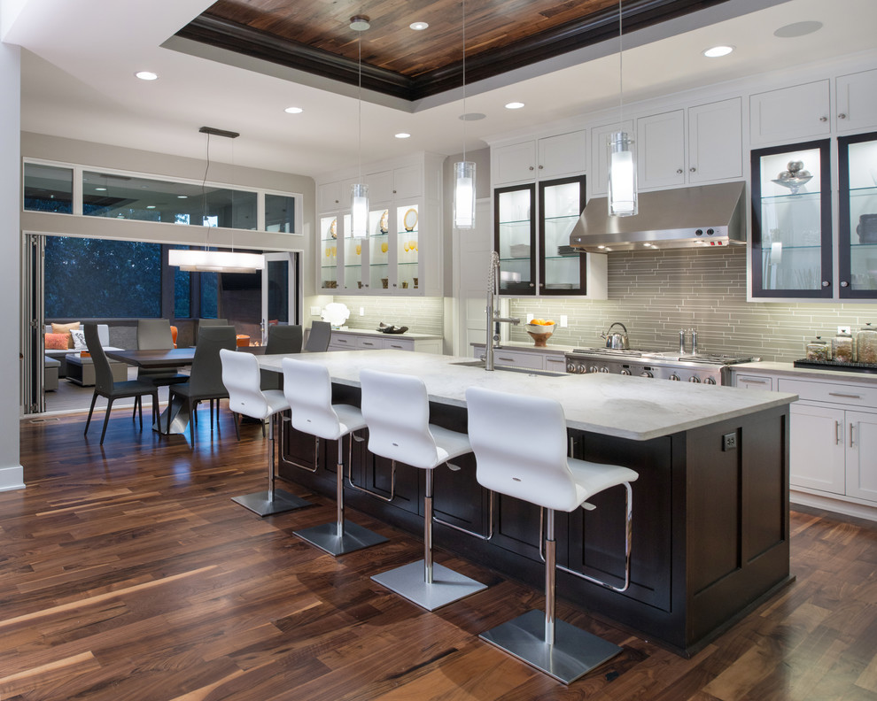 Inspiration for a large contemporary eat-in kitchen in Kansas City with shaker cabinets, white cabinets, grey splashback, matchstick tile splashback, stainless steel appliances, dark hardwood floors, with island and brown floor.