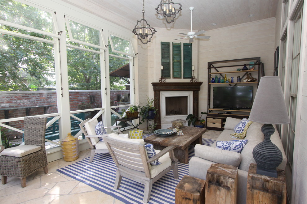 Inspiration for a mid-sized country sunroom in New Orleans with a corner fireplace, a wood fireplace surround, a standard ceiling and beige floor.