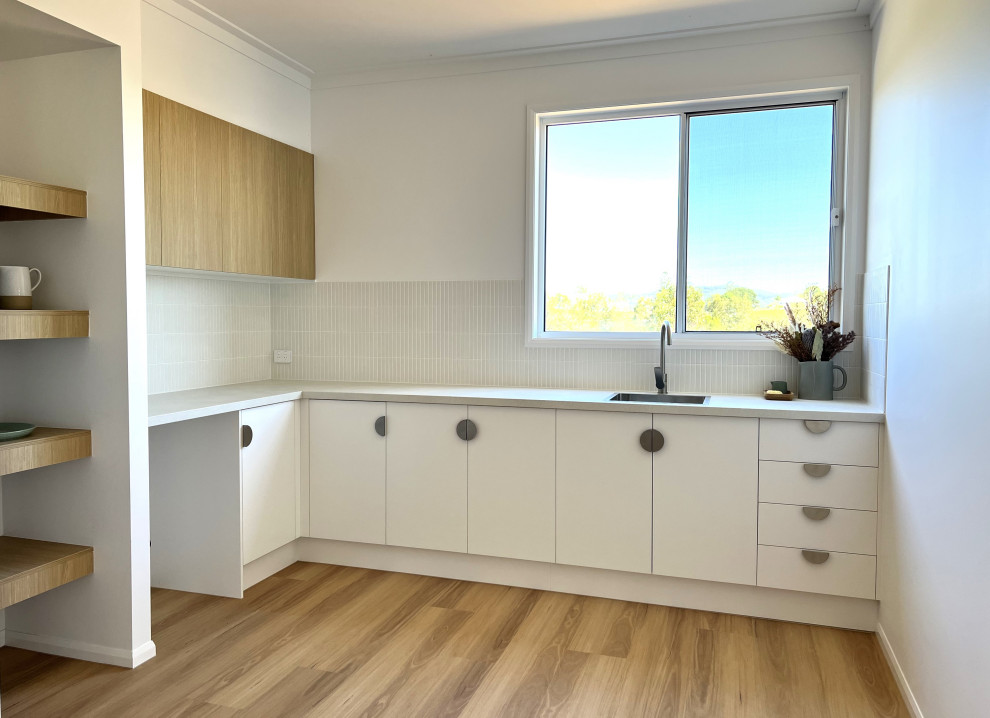 Design ideas for a contemporary l-shaped wet bar in Sunshine Coast with a drop-in sink, flat-panel cabinets, white cabinets, laminate benchtops, grey splashback, matchstick tile splashback and white benchtop.