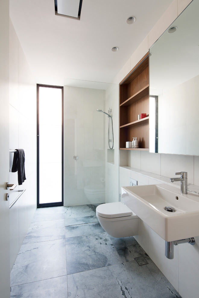 Mid-sized contemporary bathroom in Sydney with medium wood cabinets, a wall-mount toilet, white tile, ceramic tile, white walls and marble benchtops.