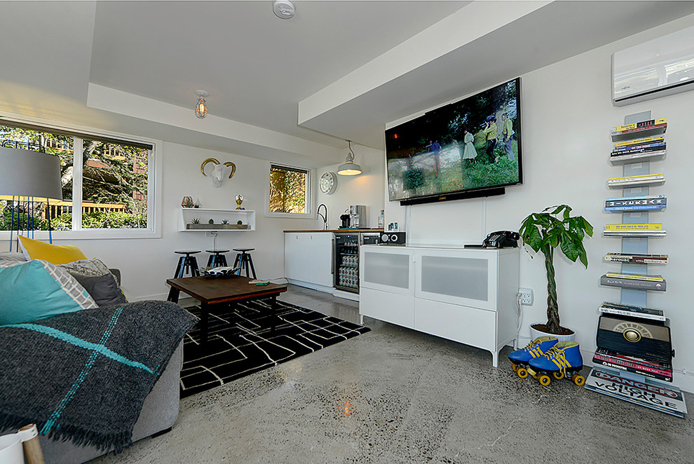 Inspiration for a large modern enclosed family room in Seattle with a music area, white walls, concrete floors, a wall-mounted tv and grey floor.