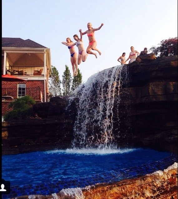 Example of a huge mountain style backyard stamped concrete and custom-shaped natural pool fountain design
