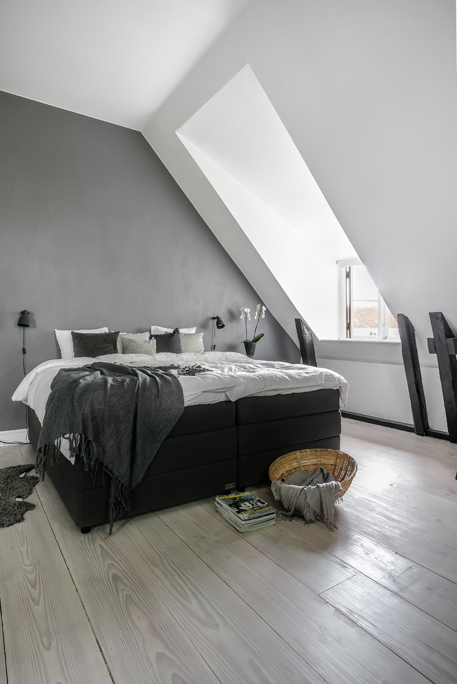 This is an example of a mid-sized scandinavian master bedroom in Malmo with grey walls, light hardwood floors and grey floor.