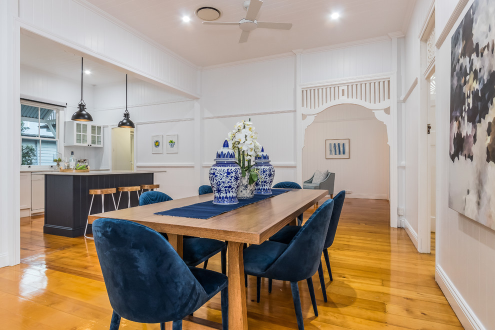 Photo of a beach style kitchen/dining combo in Brisbane with white walls, medium hardwood floors and brown floor.