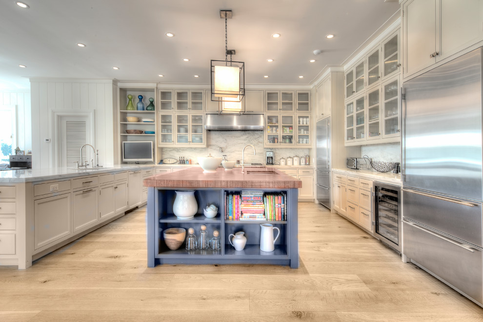 Inspiration for a mid-sized transitional u-shaped separate kitchen in New York with an undermount sink, glass-front cabinets, white cabinets, wood benchtops, multi-coloured splashback, marble splashback, stainless steel appliances, light hardwood floors, with island and beige floor.