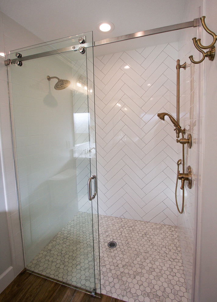 Medium sized traditional ensuite bathroom in Tampa with shaker cabinets, blue cabinets, a built-in shower, a one-piece toilet, white tiles, porcelain tiles, grey walls, porcelain flooring, a submerged sink, engineered stone worktops, brown floors and a sliding door.