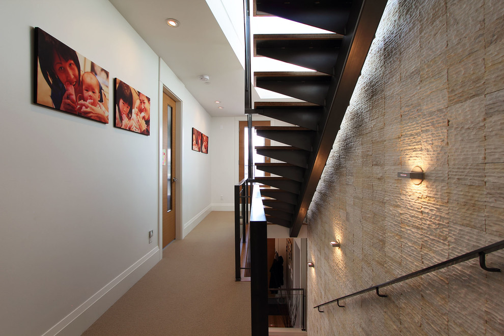 This is an example of a contemporary wood straight staircase in Vancouver with open risers.