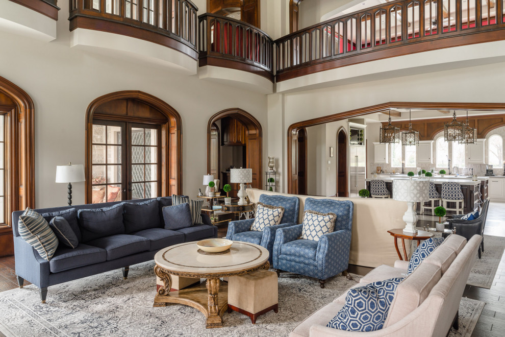 Photo of a traditional open concept living room in Houston with white walls, dark hardwood floors, a standard fireplace, a stone fireplace surround, a wall-mounted tv and brown floor.