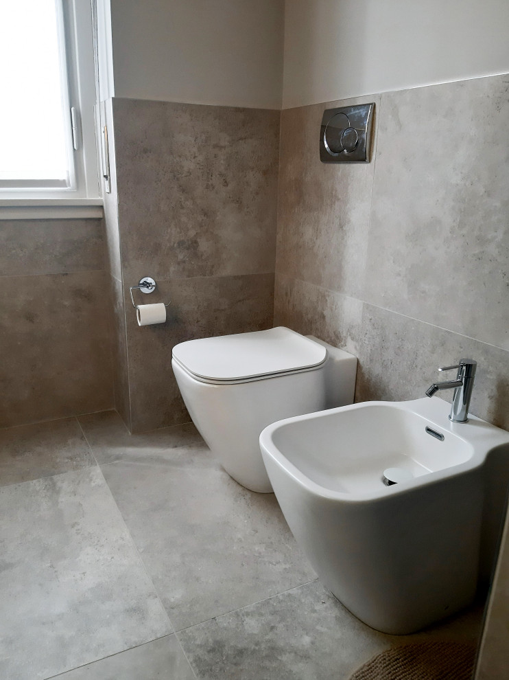 Bild på ett mellanstort funkis brun brunt badrum med dusch, med släta luckor, grå skåp, en dusch i en alkov, en toalettstol med separat cisternkåpa, grå kakel, porslinskakel, grå väggar, klinkergolv i porslin, ett fristående handfat, träbänkskiva, grått golv och dusch med gångjärnsdörr