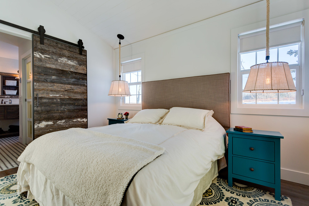 Country master bedroom in Calgary with white walls and dark hardwood floors.