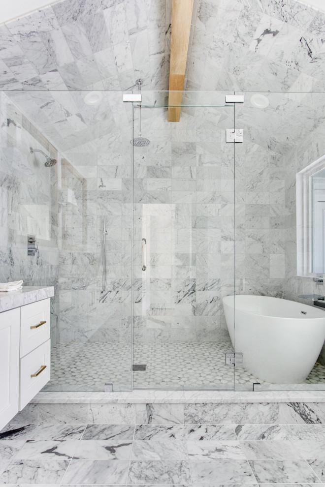 Inredning av ett 60 tals stort vit vitt en-suite badrum, med skåp i shakerstil, vita skåp, ett fristående badkar, en dusch/badkar-kombination, en toalettstol med separat cisternkåpa, vit kakel, vita väggar, ett undermonterad handfat, vitt golv, dusch med gångjärnsdörr, marmorkakel, marmorgolv och marmorbänkskiva