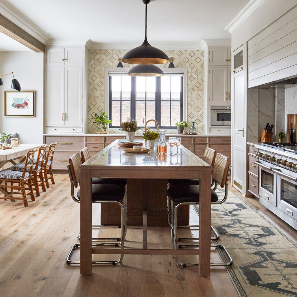 Foto på ett eklektiskt gul kök och matrum, med luckor med infälld panel, vita skåp, bänkskiva i kvartsit, vitt stänkskydd, rostfria vitvaror, ljust trägolv, en köksö och brunt golv