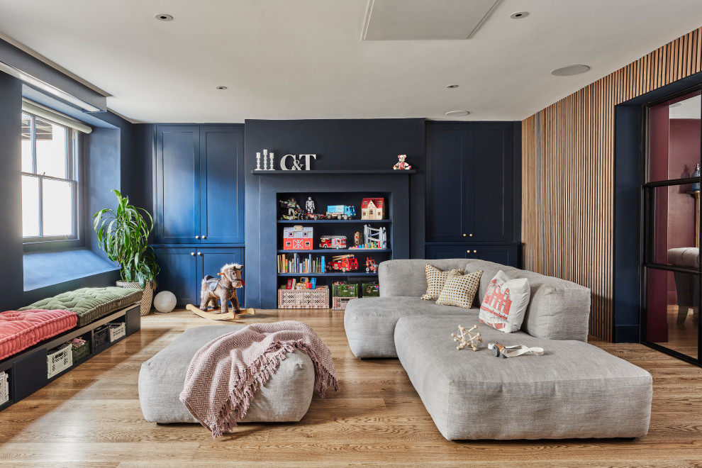 Ejemplo de sala de estar ecléctica con paredes azules, suelo de madera en tonos medios y suelo marrón