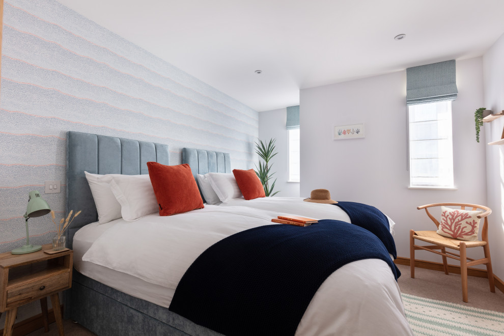 На фото: гостевая спальня среднего размера, (комната для гостей) в морском стиле с белыми стенами, ковровым покрытием, бежевым полом, обоями на стенах и акцентной стеной без камина