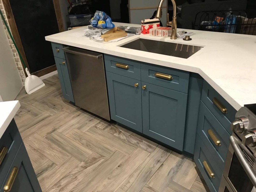 Photo of a mid-sized transitional u-shaped eat-in kitchen in Houston with turquoise cabinets, white splashback, stainless steel appliances, laminate floors, with island, beige floor, white benchtop, coffered, an undermount sink, shaker cabinets, quartzite benchtops and ceramic splashback.
