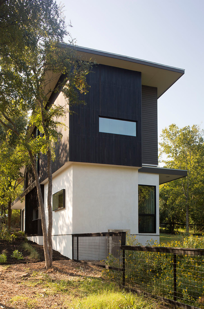 Inspiration for a small contemporary two-storey white exterior in Austin with wood siding and a flat roof.
