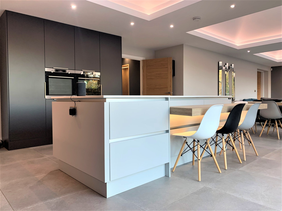 Eat-in kitchen - large contemporary l-shaped vinyl floor and gray floor eat-in kitchen idea in Other with a single-bowl sink, flat-panel cabinets, light wood cabinets, quartzite countertops, black appliances, an island and white countertops