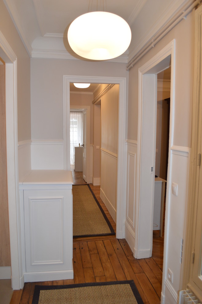 Photo of a mid-sized traditional hallway in Paris with grey walls and light hardwood floors.
