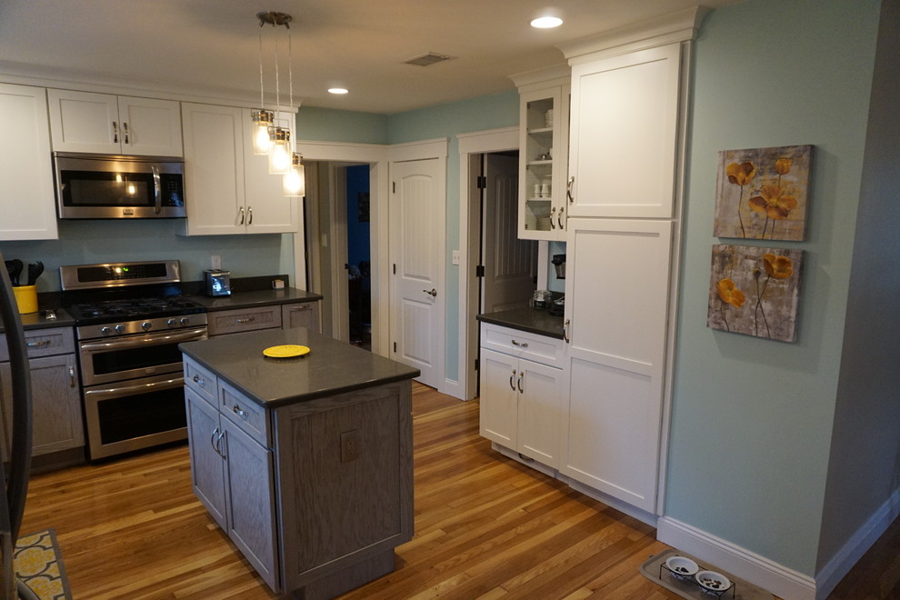 Inspiration for a mid-sized transitional u-shaped medium tone wood floor eat-in kitchen remodel in Boston with an undermount sink, shaker cabinets, gray cabinets, quartz countertops, black backsplash, stainless steel appliances and an island