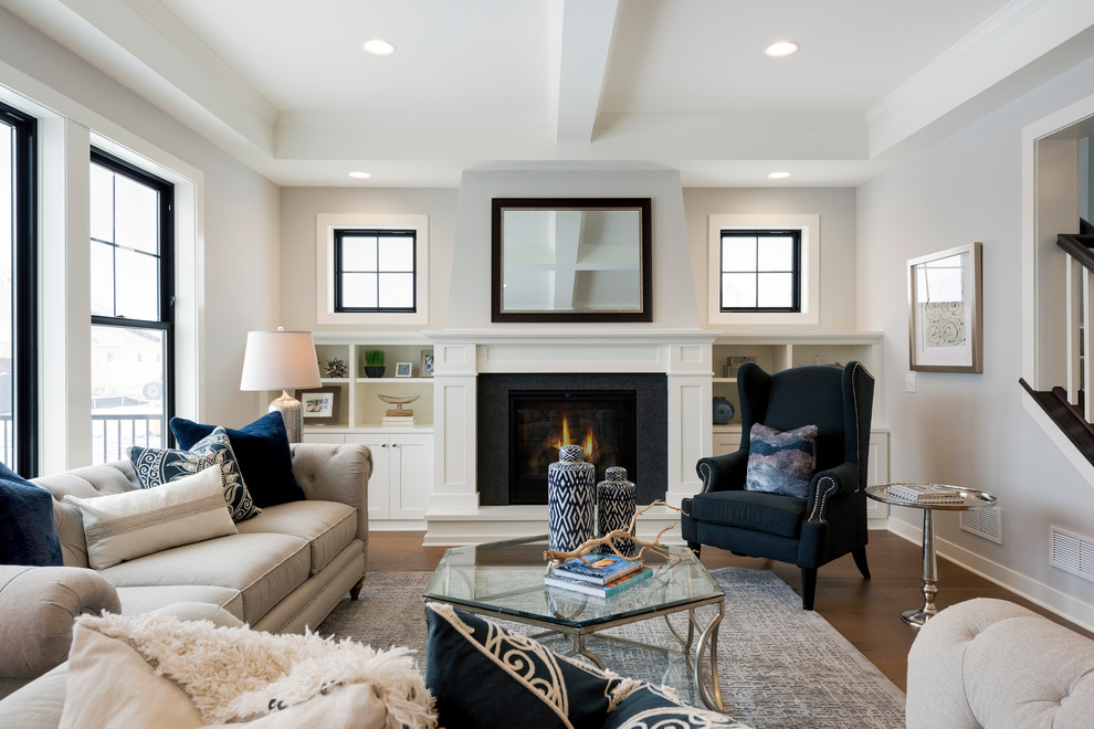 Photo of a transitional living room in Minneapolis with white walls, medium hardwood floors, a standard fireplace and brown floor.