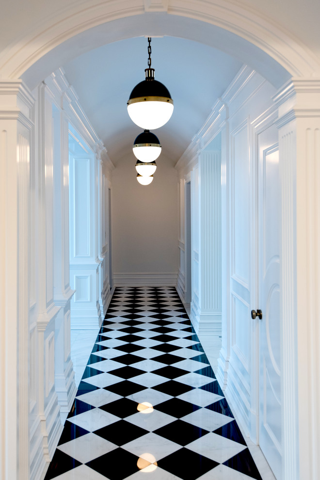 Photo of a large traditional hallway in New York with white walls and marble floors.