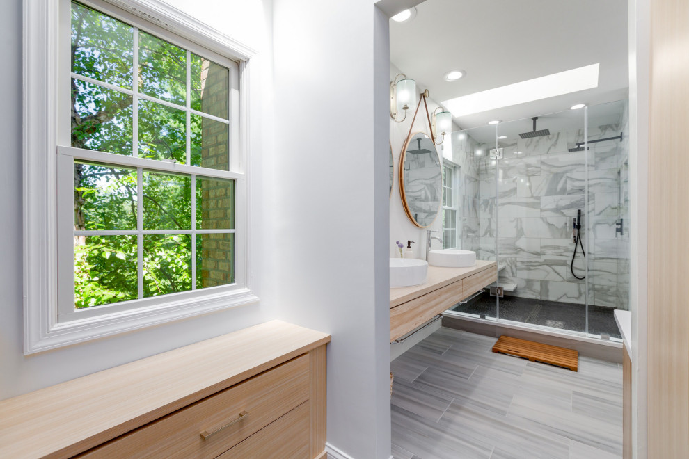 Design ideas for a contemporary bathroom in DC Metro with flat-panel cabinets, light wood cabinets, a one-piece toilet, white tiles, porcelain tiles, a vessel sink, engineered stone worktops, a hinged door, white worktops, double sinks and a floating vanity unit.