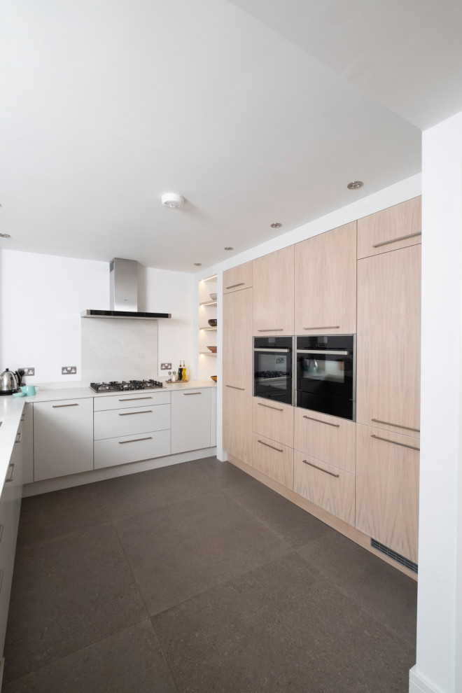 Design ideas for a large contemporary u-shaped kitchen in Cardiff with flat-panel cabinets, white cabinets, grey splashback, panelled appliances, no island, grey floor and grey benchtop.
