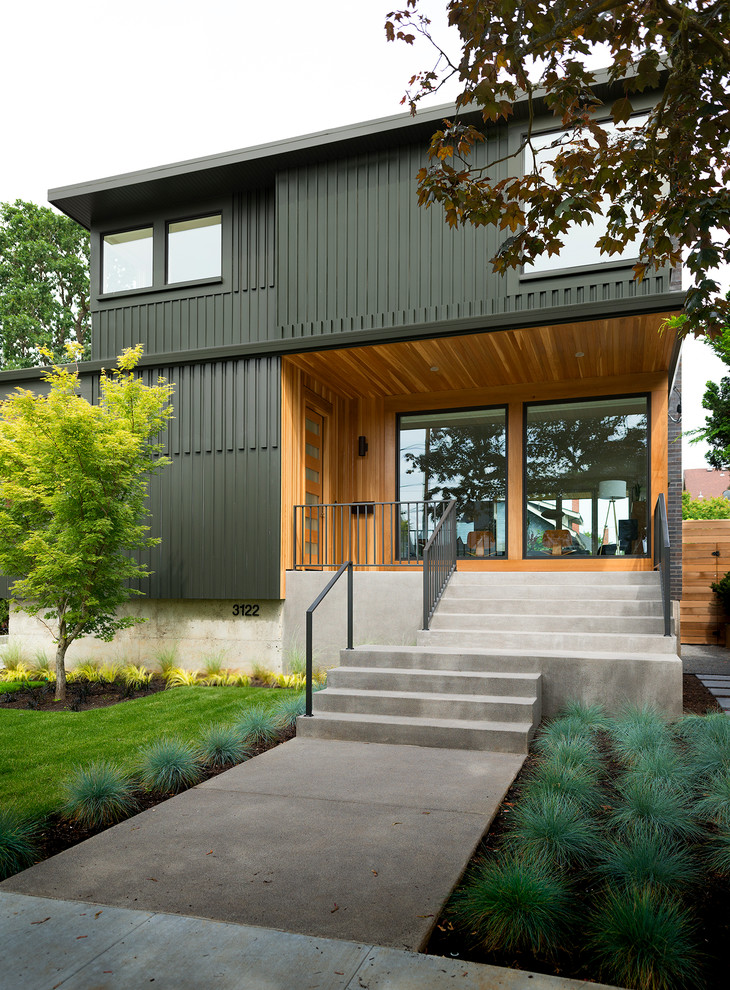 Inspiration for a large modern two-storey green exterior in Portland with mixed siding and a flat roof.
