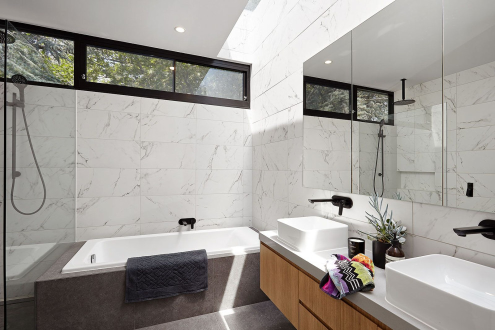 Design ideas for a contemporary bathroom in Melbourne with flat-panel cabinets, medium wood cabinets, a drop-in tub, white tile, a vessel sink, grey floor and white benchtops.