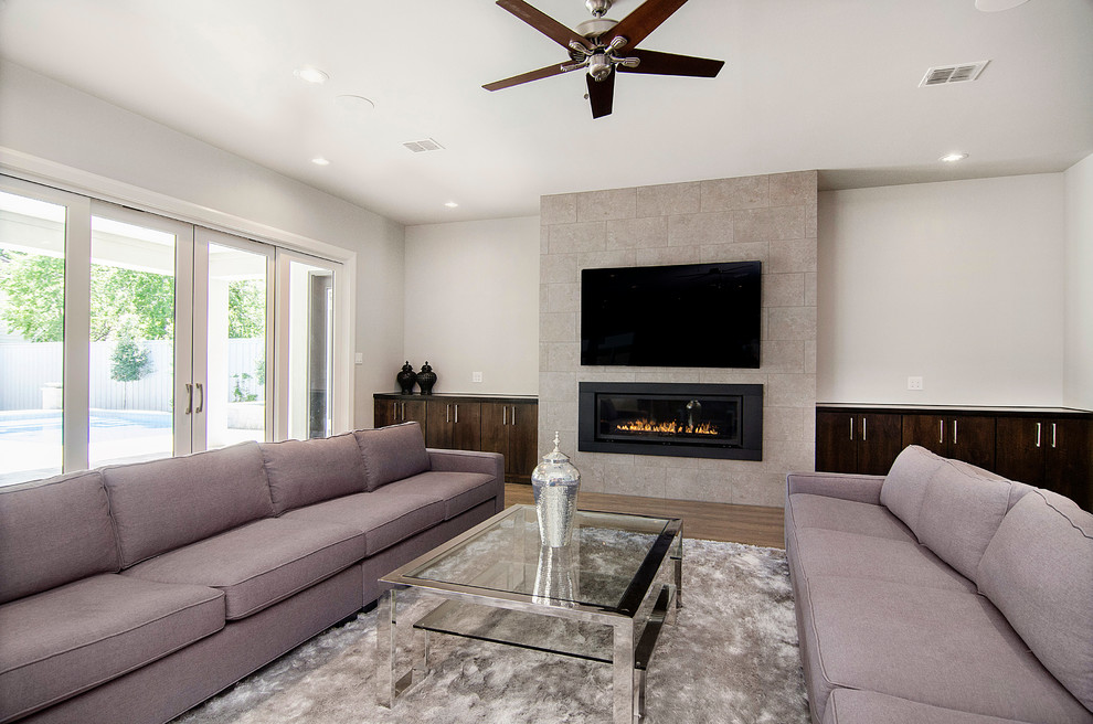 Inspiration for an expansive transitional open concept living room in Dallas with a wall-mounted tv, grey walls, a ribbon fireplace, a tile fireplace surround and medium hardwood floors.