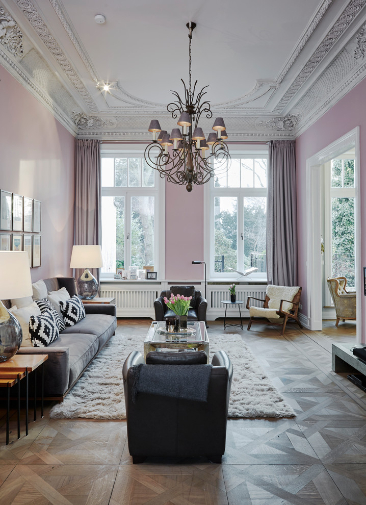 Offenes, Großes Wohnzimmer mit rosa Wandfarbe, gebeiztem Holzboden und grauem Boden in Hamburg