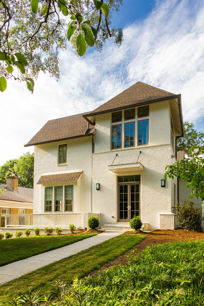 Photo of a large transitional three-storey brick white exterior in Atlanta with a hip roof.