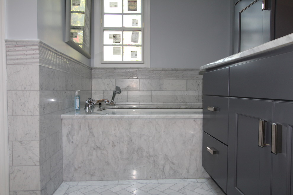 Mid-sized transitional master bathroom in DC Metro with recessed-panel cabinets, black cabinets, an undermount tub, a corner shower, gray tile, porcelain tile, grey walls, marble floors, an undermount sink, marble benchtops, white floor and a hinged shower door.