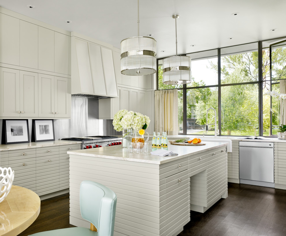 Eat-in kitchen - transitional eat-in kitchen idea in Austin with a farmhouse sink, beige cabinets, metallic backsplash, stainless steel appliances and an island
