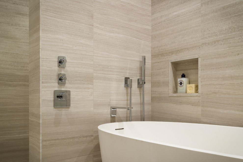 Photo of a small modern master bathroom in New York with a freestanding tub, beige tile, limestone, beige walls, limestone floors, limestone benchtops and beige floor.